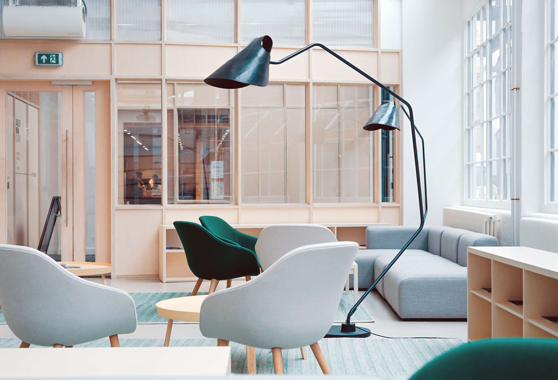 Bright, modern office lounge with lounge chairs, sofa and floor lamp